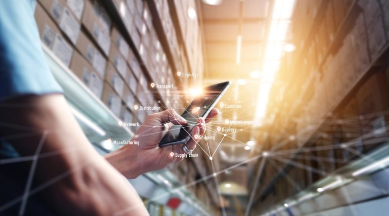 Person holding a mobile phone in a warehouse