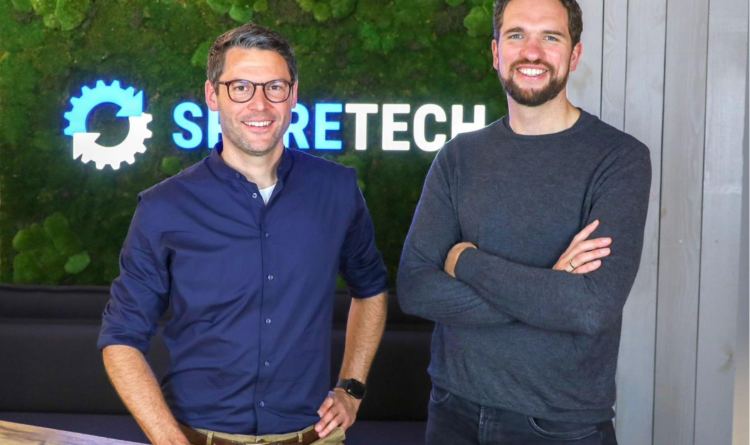 Two executives from SPARETECH standing in front of company logo