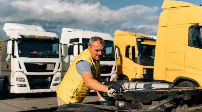 A mechanic performing maintenance checks on a fleet of well-maintained vehicles.