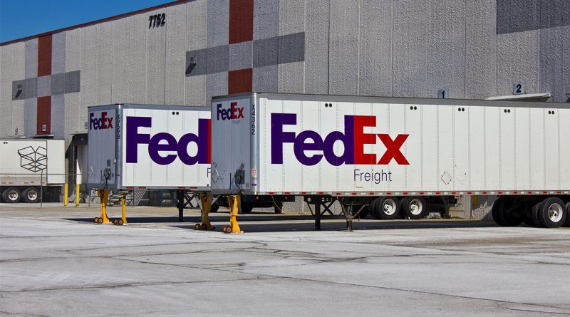 A FedEx Freight truck parked at a distribution center under overcast skies