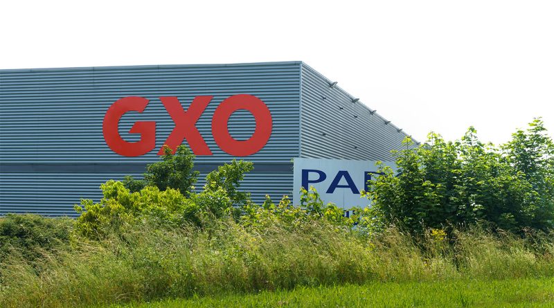 A GXO Logistics warehouse with automated systems and staff in motion, representing growth in logistics operations and strategic expansion