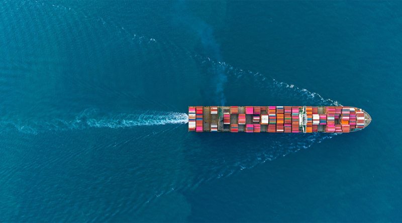 Cargo containers stacked at the Port of Los Angeles with cranes idle during a slowdown in shipments from China to the US.