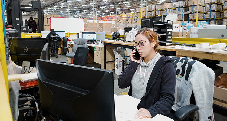 GPA Logistics Group is transforming the logistics landscape with innovative technology and personalized service woman working at a desk within an office area inside a large industrial warehouse or fulfillment center