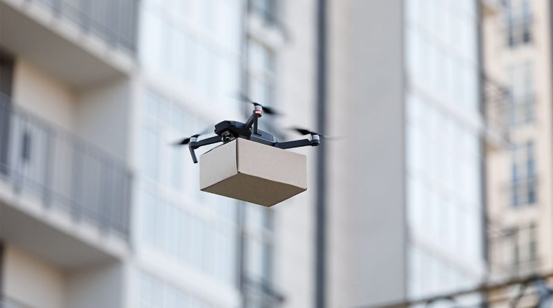 Zipline autonomous delivery drone flying over a city with packages below illustrating supply chain aerial logistics