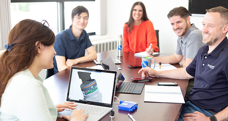 Upholding a 174-year legacy, Ashcroft’s culture drives its leadership in pressure and temperature measurement solutions a group of five business professionals or colleagues having a meeting around a table in a modern office