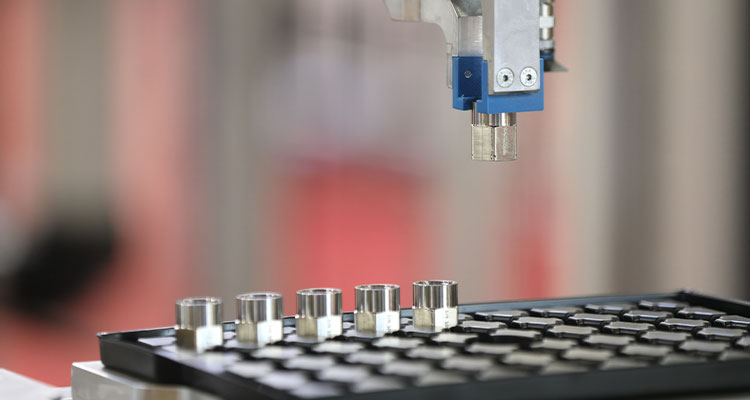 n automated industrial process involving a robotic arm and several metal components